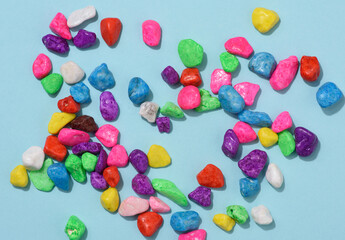 multicolored decorative stones on a blue background, top view. decor for flowerpots