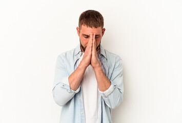 Young caucasian man with diastema isolated on white background praying, showing devotion, religious...