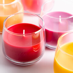 Beautiful colored candles in glass on white background. Aroma candles with colorful wax. square
