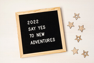 Letter board with text 2022 say yes to new adventures. Motivational quote, new year goals and resolution concept. Flat lay, top view