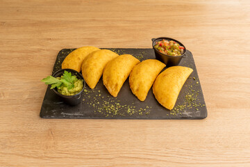 Ration of Colombian corn empanadas with guacamole and pico de gallo to dip with oregano