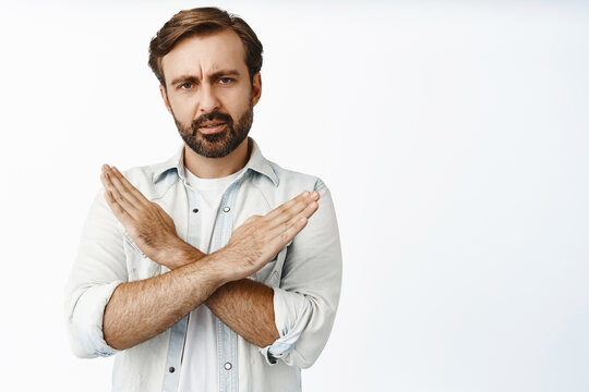Very bad. Serious and disappointed man showing cross sign and furrow eyebrows upset, prohibit, disagree and reject offer, tell to stop, white background