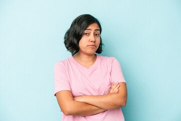 Obraz premium Young latin woman isolated on blue background suspicious, uncertain, examining you.