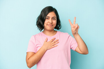 Young latin woman isolated on blue background taking an oath, putting hand on chest.