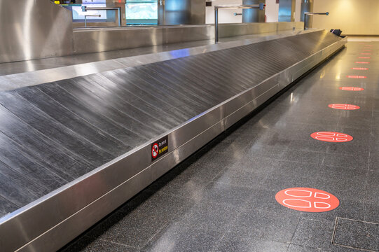 Leeres Gepäckband in einem Terminal als Symbol eines verlorenen Koffers