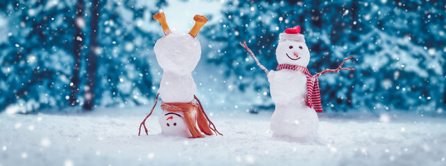 Cheerful snowmen standing in magical winter forest