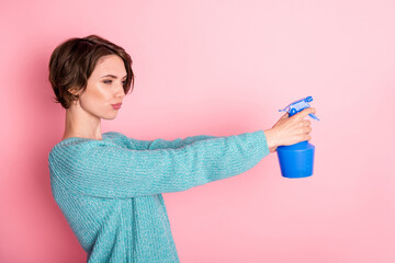 Profile side photo of funky charming young woman hold pulverizer shoot empty space isolated on pink...