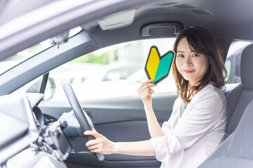 初心者マークを持った若い女性ドライバー