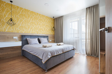 a bed with a soft headboard in a Scandinavian-style bedroom in yellow tones