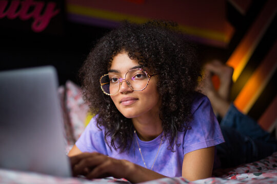 Young adult gen z female student using a laptop in her bedroom