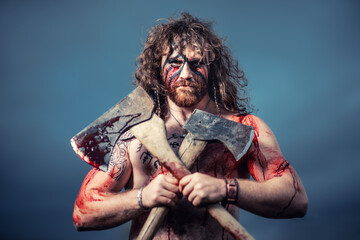 Medieval warrior berserk Viking portrait with tattoo on skin, cuts on body and braids in hair with weapons to attacks enemy. Concept historical photo