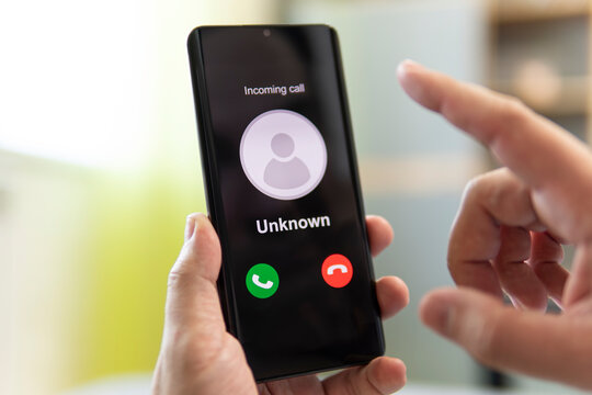 Unknown caller. A man holds a phone in his hand and thinks to end the call. Incoming from an unknown number. Incognito or anonymous