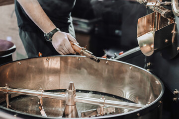 Fototapeta premium Fresh roasted coffee. Roasting process of coffee beans at factory