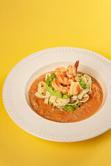 Spaghetti with prawns and vegetables on white dish