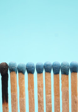 Matches against a blue background, one burned out
