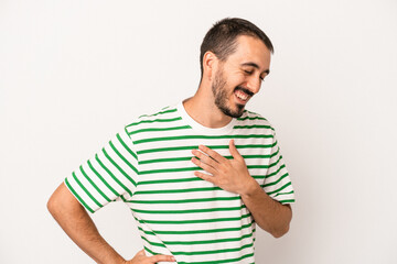 Young caucasian man isolated on white background laughing keeping hands on heart, concept of happiness.