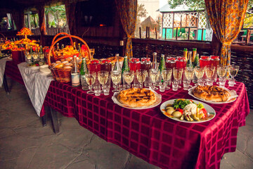 Russian feas. A table set with Russian snacks - pies with stuffing, pickles, drinks poured into glasses