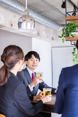 お酒を飲みながら話すビジネスパーソン