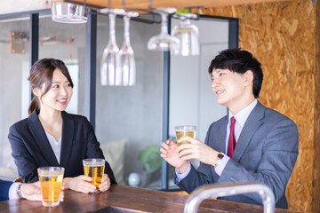お酒を飲みながら話すビジネスパーソン