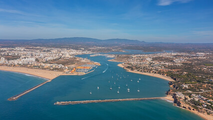 Fototapeta na wymiar Aerial view of the panorama of the sea bay of Portimao, marinas with luxury yachts. Passing ships with tourists.