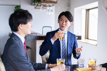 お酒を飲みながら話すビジネスパーソン