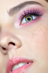 Closeup shot of human female face with pink makeup