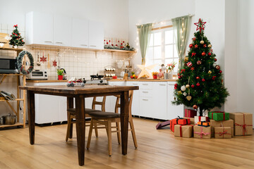 modern cozy kitchen dining room interior with new year decorations and Christmas tree with gifts underneath