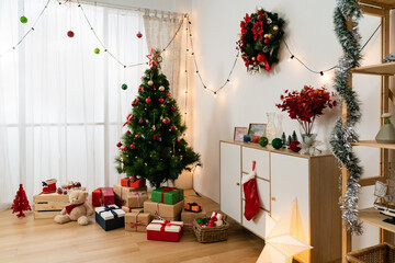 decorated Christmas tree with wrapped presents under it and festive decors in a modern cozy room interior