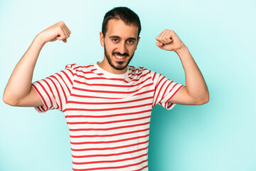 Fototapeta premium Young caucasian man isolated on blue background cheering carefree and excited. Victory concept.