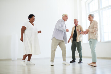 Group of senior people having fun and dancing together in dance studio