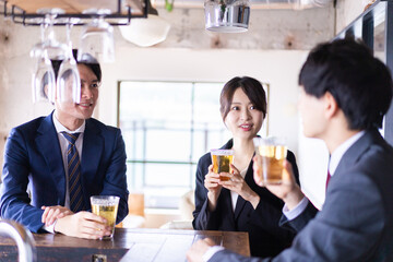 バーでお酒を飲む男女の会社員
