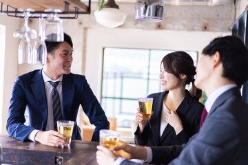 バーでお酒を飲む男女の会社員