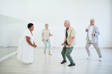 Senior people taking dance lessons in a dance studio, they enjoying the dance and music
