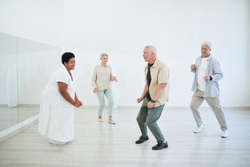 Naklejka premium Senior people taking dance lessons in a dance studio, they enjoying the dance and music