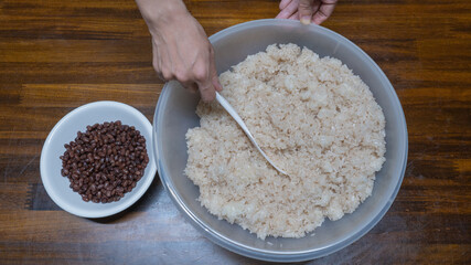 日本の料理・赤飯を作る。小豆と米を混ぜる。”Festive red rice”