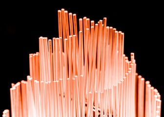 Orange glowing glass rods on black background.