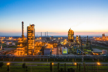 Oil refinery plant industry, Refinery factory. oil storage tank, rectification column and pipeline against the backdrop of sunset in summer, Russia