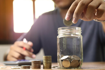 businessman holding coins putting in glass. concept saving money for finance accounting.