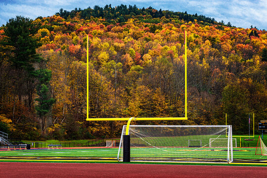 Small yellow football goals on a stadium field during autumn