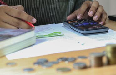 businessman working on desk office with using a calculator to calculate the numbers, finance...