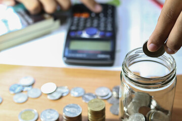 businessman holding coins putting in glass. concept saving money for finance accounting.