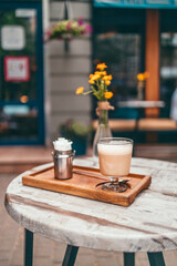 Fragrant cappuccino coffee cup on a wooden table on cozy vintage terrace in a street cafe outside