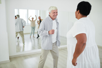 Active happy senior people learning new dance during lesson in the studio