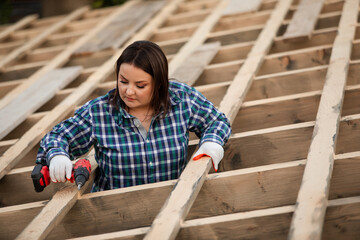 The young woman worker make frame of the roof