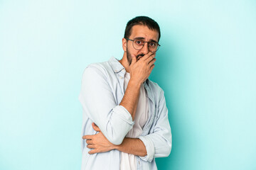 Young caucasian man isolated on blue background scared and afraid.