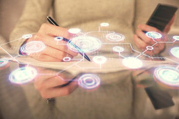 Double exposure of social network sketch hologram and woman holding and using a mobile device.