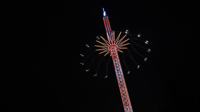 Tower Swinger Ride In Amusement Park at night at anual funfair