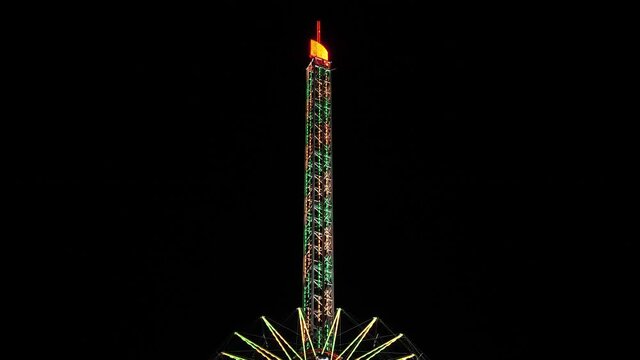 Tower Swinger Ride In Amusement Park at night at anual funfair
