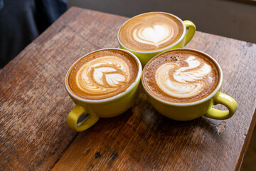 Latte coffee or cappuccino coffee in white cup with beautiful tree latte art on wooden table.