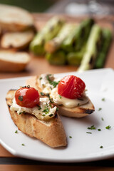 Bruschetta with baked camembert cheese, sauce and herbs